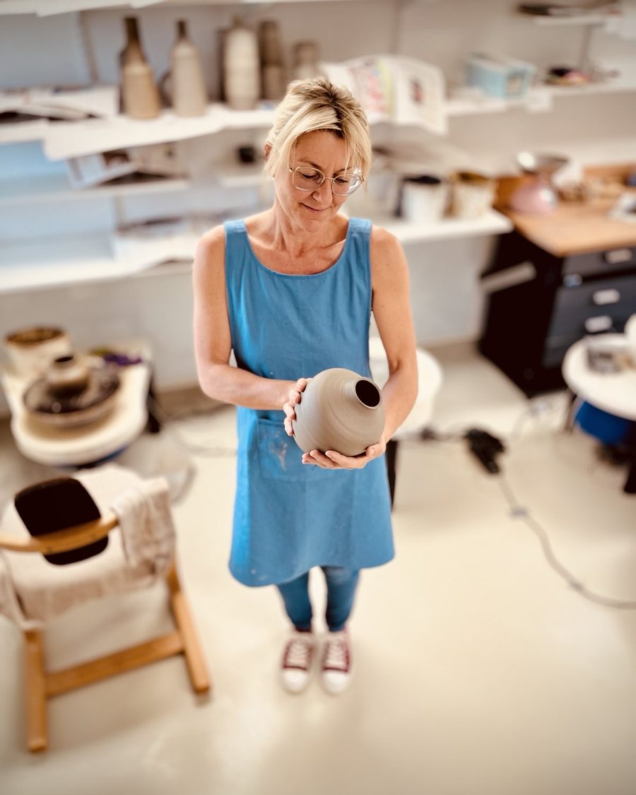 Alexandra Gauder mit einer frisch gedrehten Vase in der Werkstatt